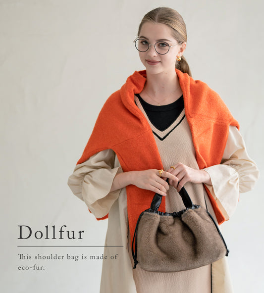 A female model is holding a tote bag "Dollfur". Color: Mocha greige
