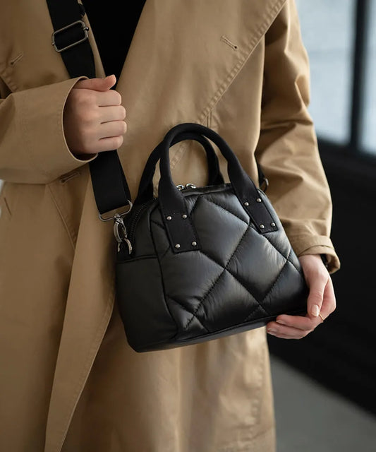A female model is carrying a body bag "peremopetit" over her shoulder.Color:Black