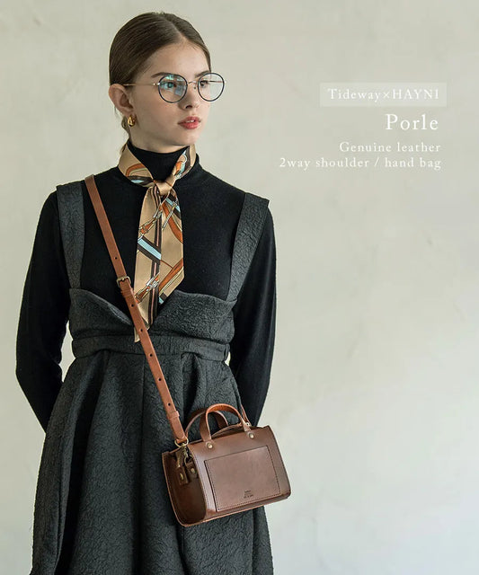 A female model is carrying a shoulder bag "Linzy" over her shoulder. Color:Brown