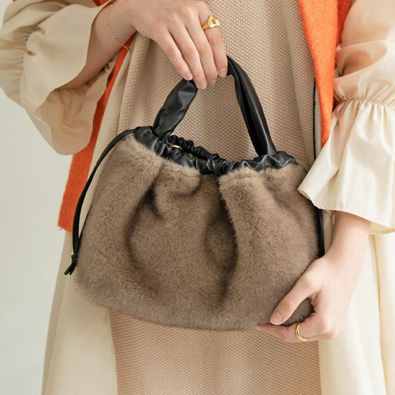 A female model is holding a tote bag "Dollfur". Color: Mocha greige