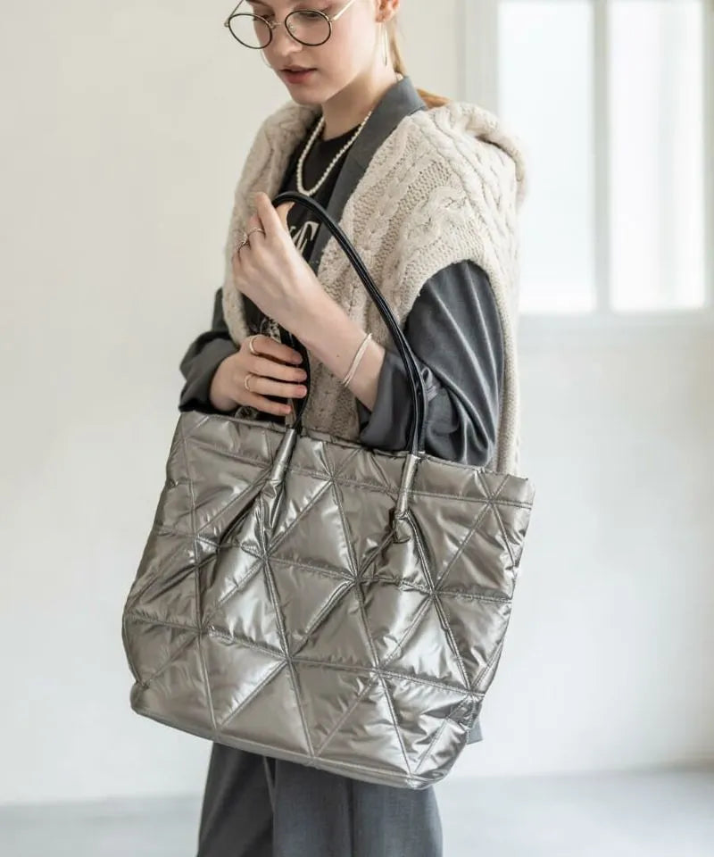 A female model is holding a quilting tote bag "Trica" Color:Silver