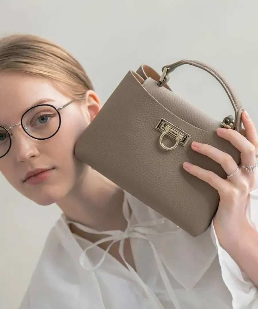 A female model is holding a tote bag “Baby Marollet”. Color: Greige(Gold hardware)