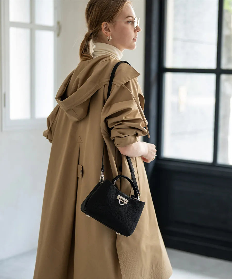 A female model is carrying a shoulder bag “Baby Marollet” over her shoulder. Color:Black