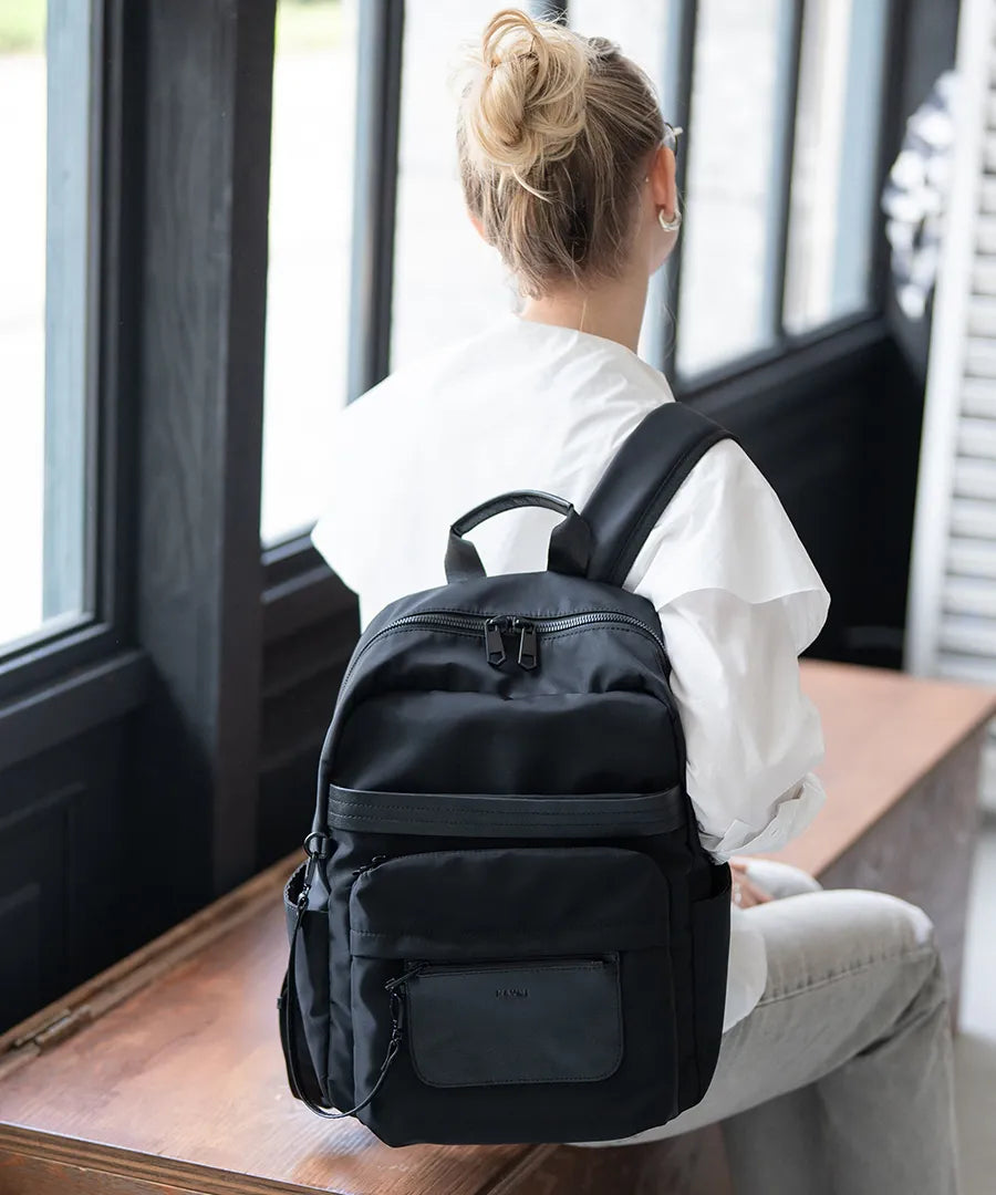 A female model sitting with a backpack "Ragalo" on her back