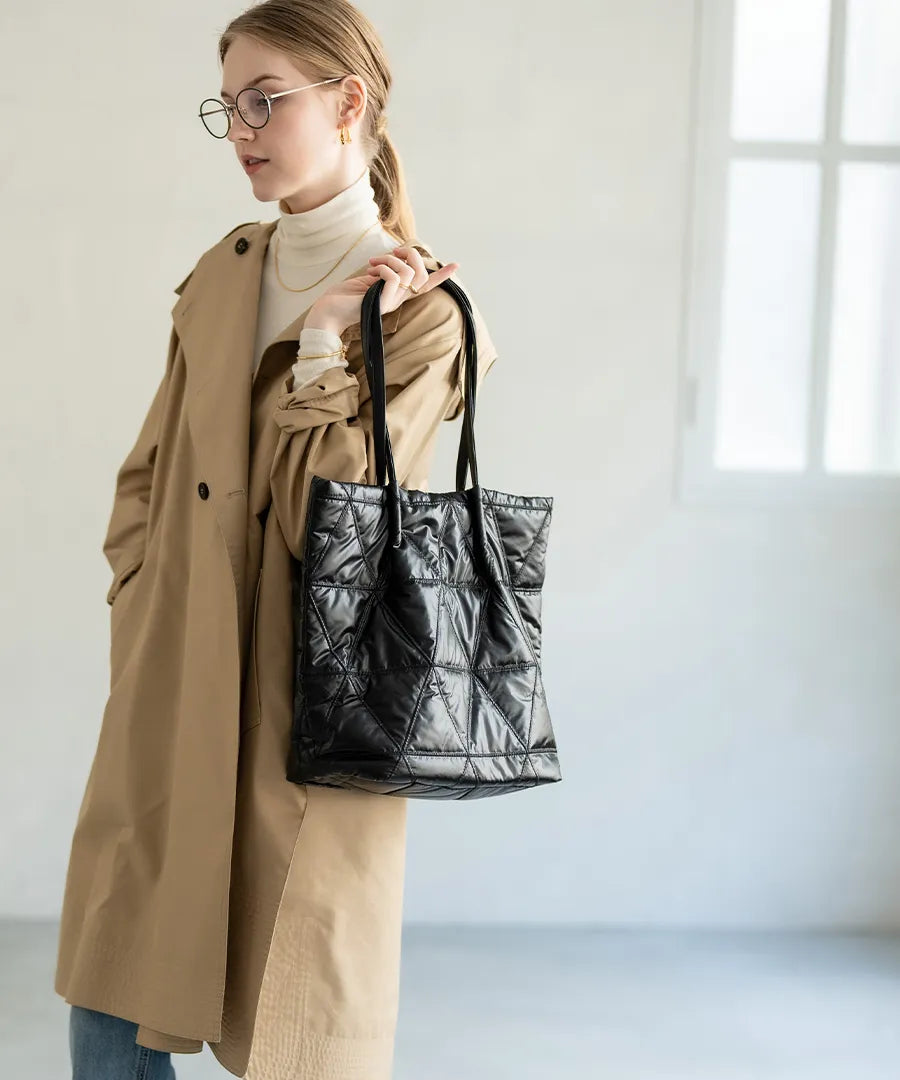 A female model is holding a quilting tote bag "Trica" Color:Black