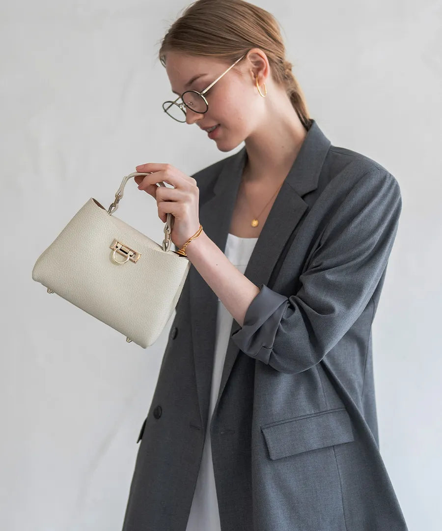 A female model is holding a tote bag "Baby Marollet". Color: Ivory