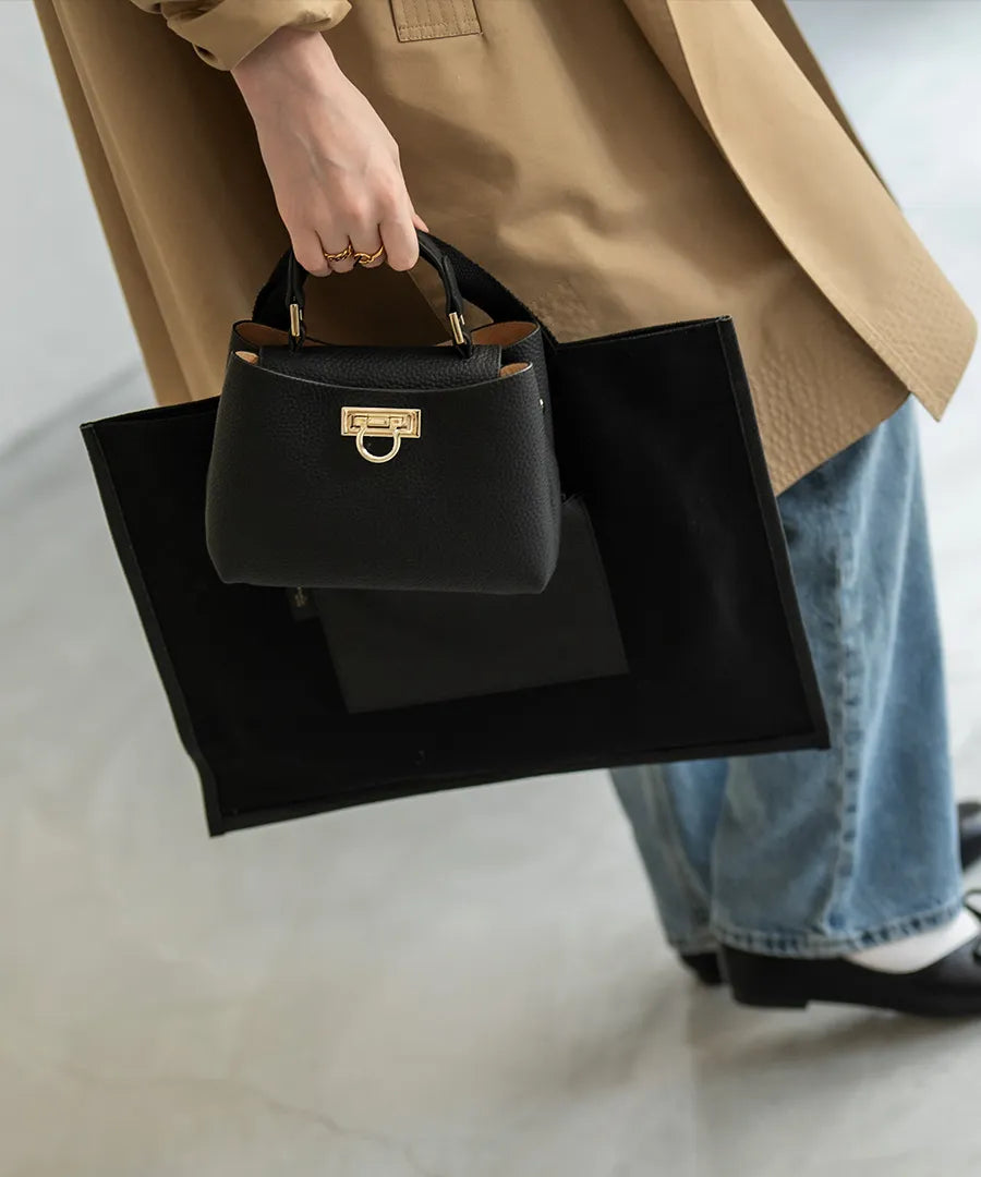 A female model is holding a tote bag "Baby Marollet". Color: Black