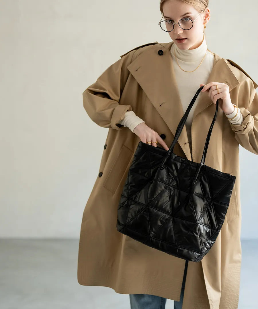 A female model is holding a quilting tote bag "Trica" Color:Black