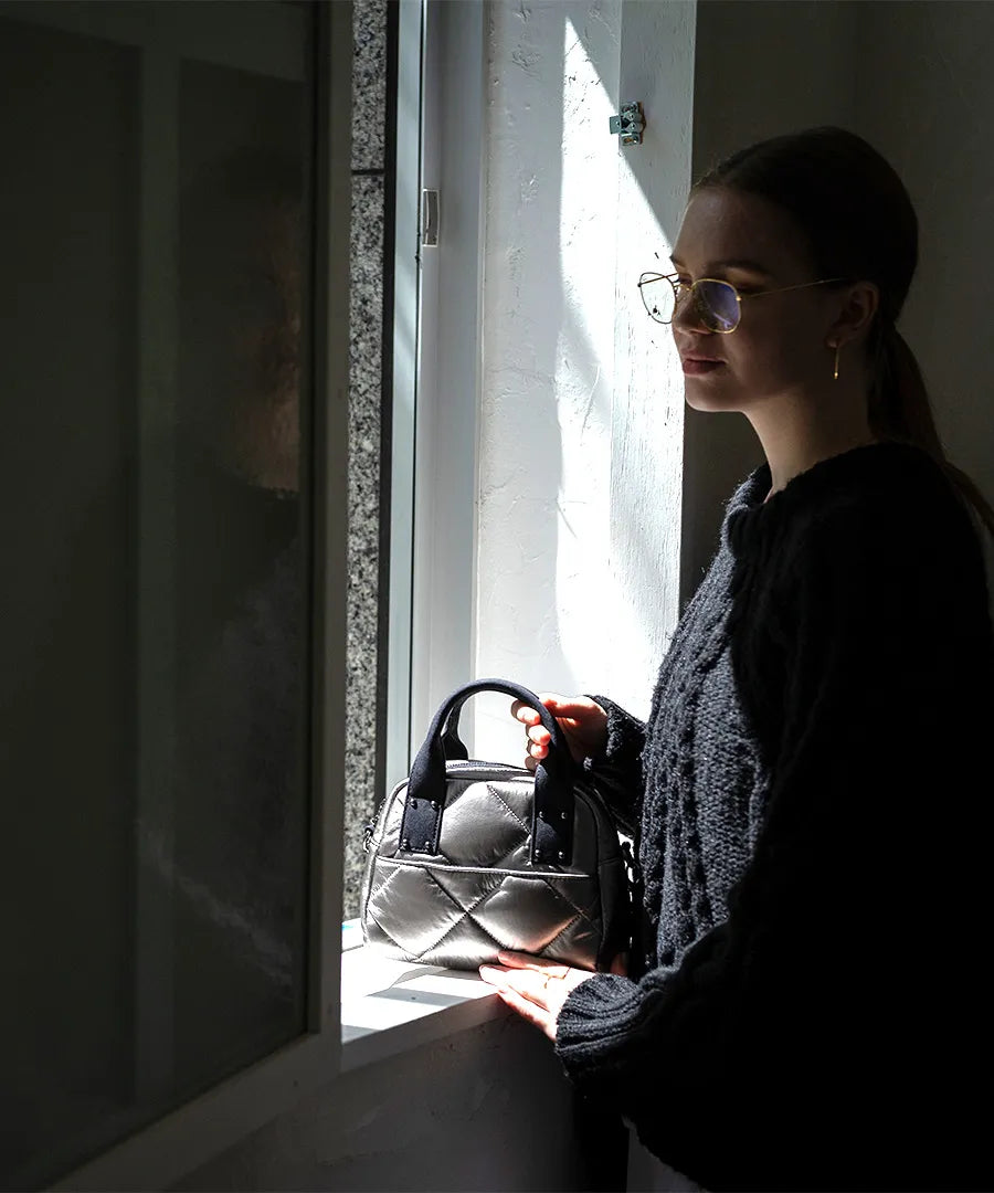 A female model is holding a tote bag "peremopetit".Color:Black