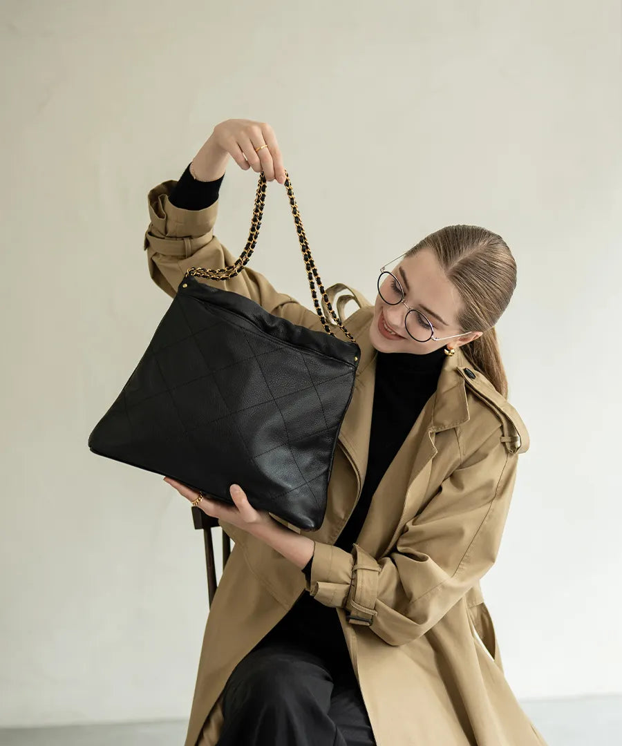 A female model is holding a shoulder bag "barmed".