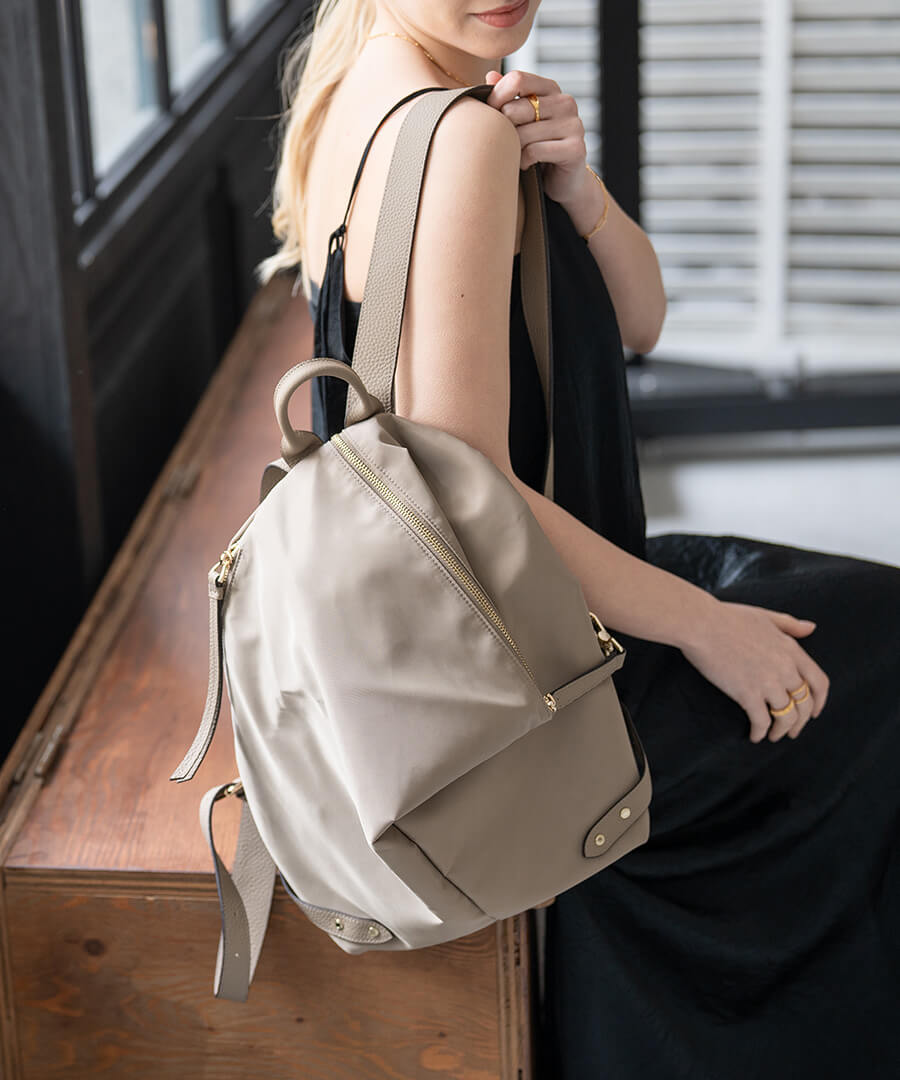 A female model is carrying a backpack "Nylon Alba". Color: Greige (Gold-color hardware)