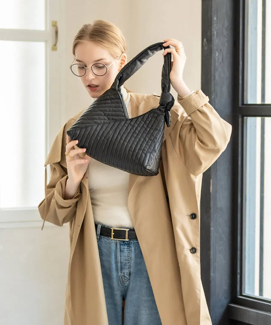 A female model is holding a hand bag "Aulie" Color:Black