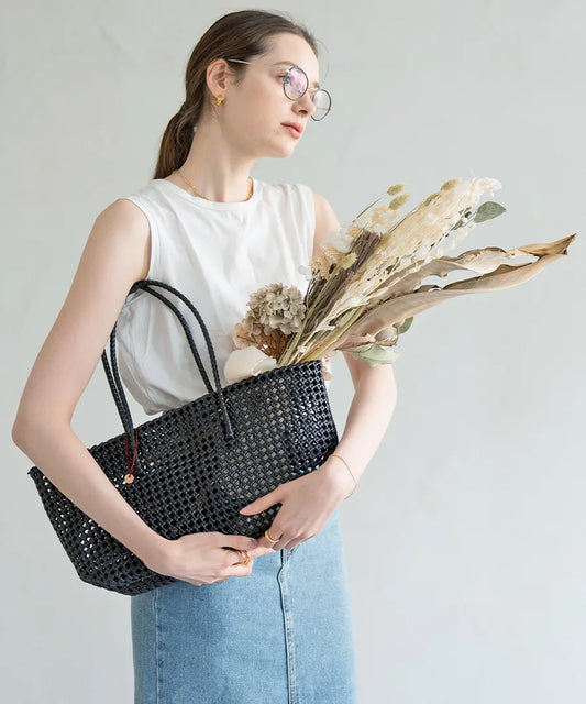The female model is holding a basket bag「Basq」Color: Black