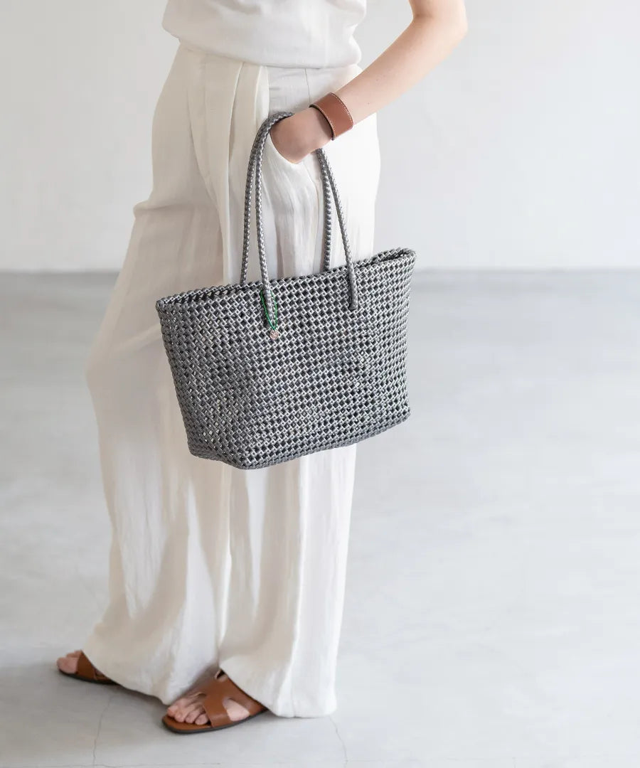 The female model is holding a basket bag「Basq」Color: gray