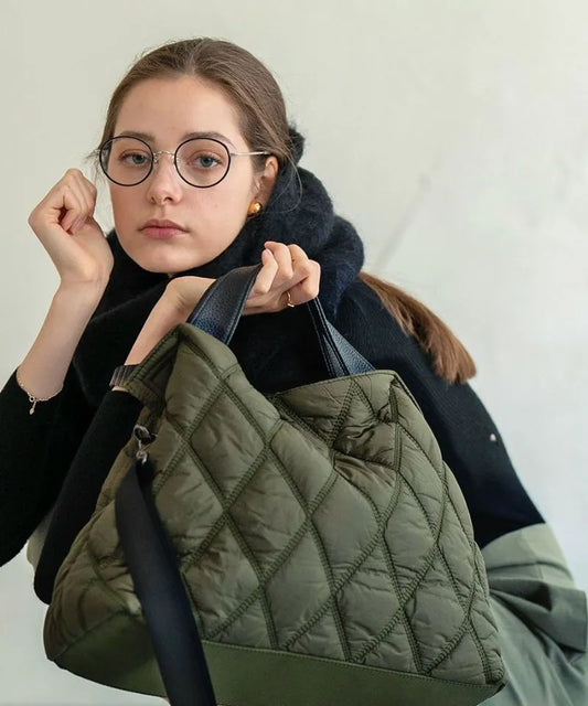 A female model is sitting and holding a tote bag "Dajia".