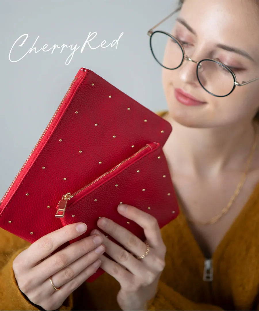 A female model is holding a leather pouch "Dotlpouch M" Color:Cherry red (gold dot)