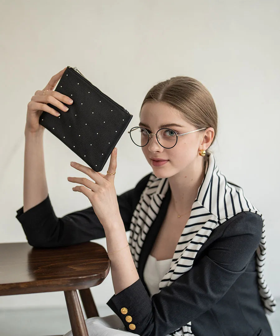 A female model is holding a leather pouch "Dotlpouch M" Color:Silver dot