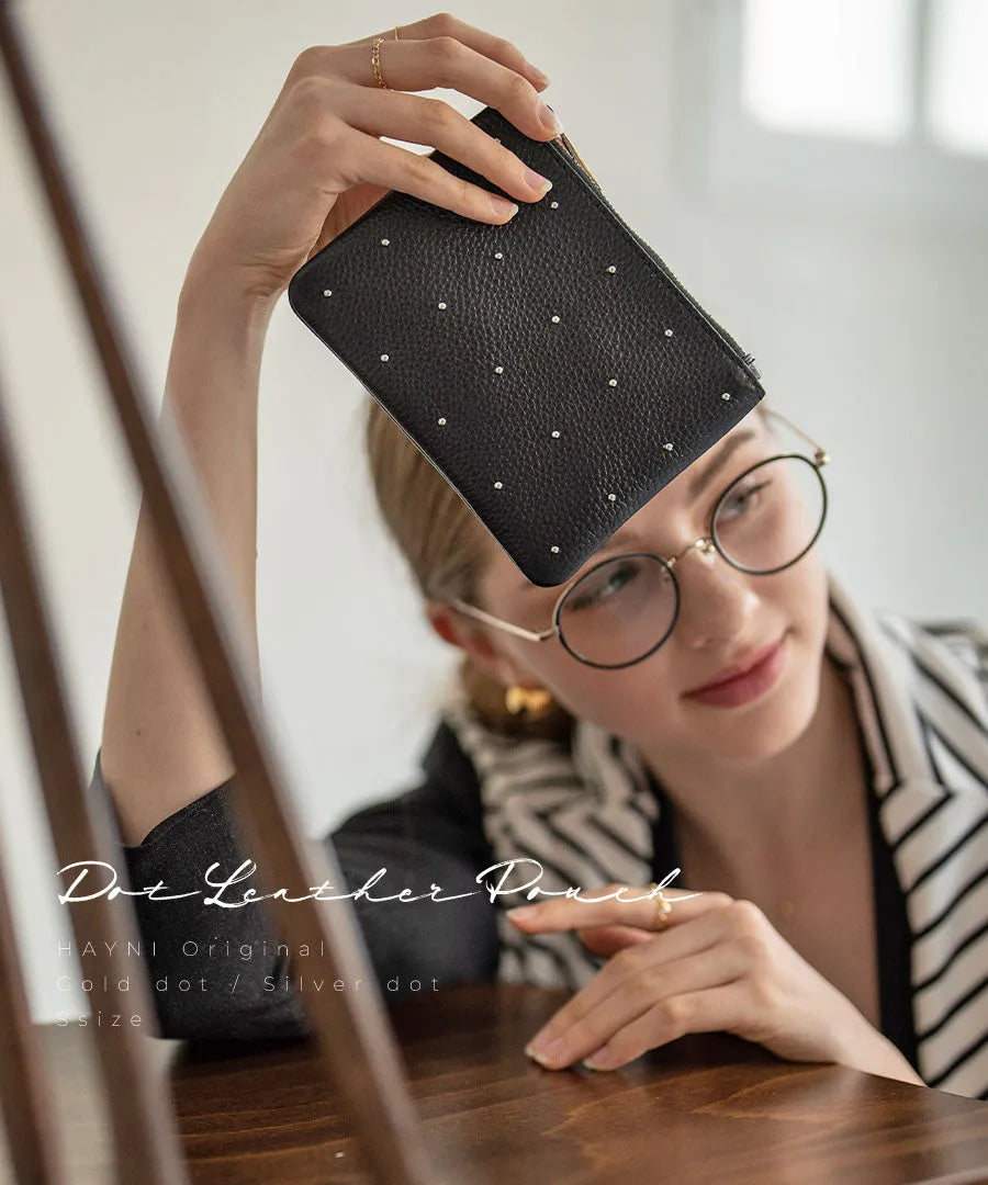 A female model is holding a leather pouch "Dotlpouch S" Color:Silver dot