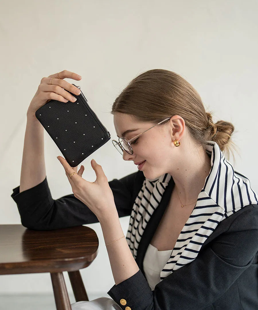 A female model is holding a leather pouch "Dotlpouch S" Color:Silver dot