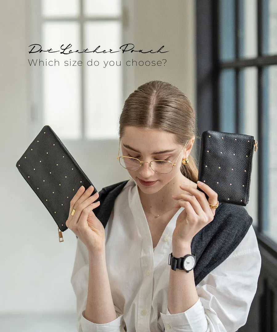 A female model is holding a leather pouch "Dotlpouch S" Color:Gold dot