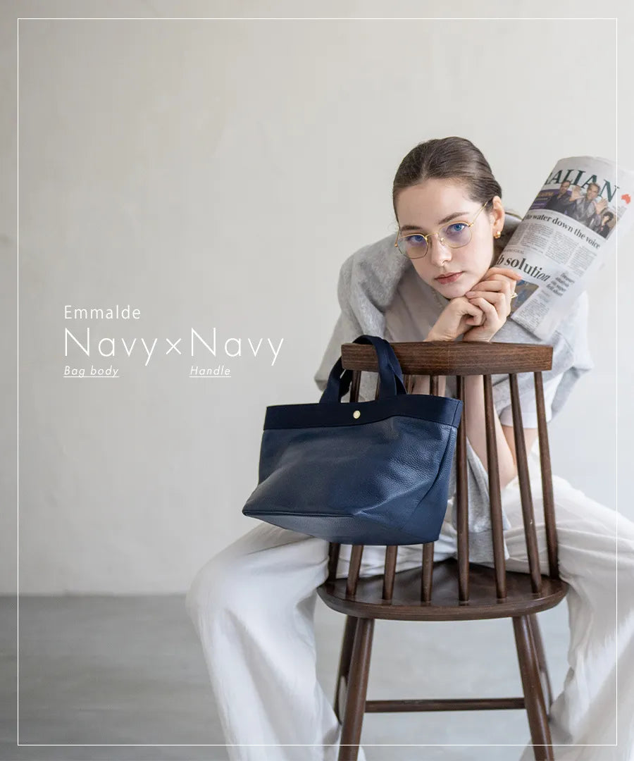 Colors of the female model sitting on a chair and the tote bag "Emalde": navy x navy.