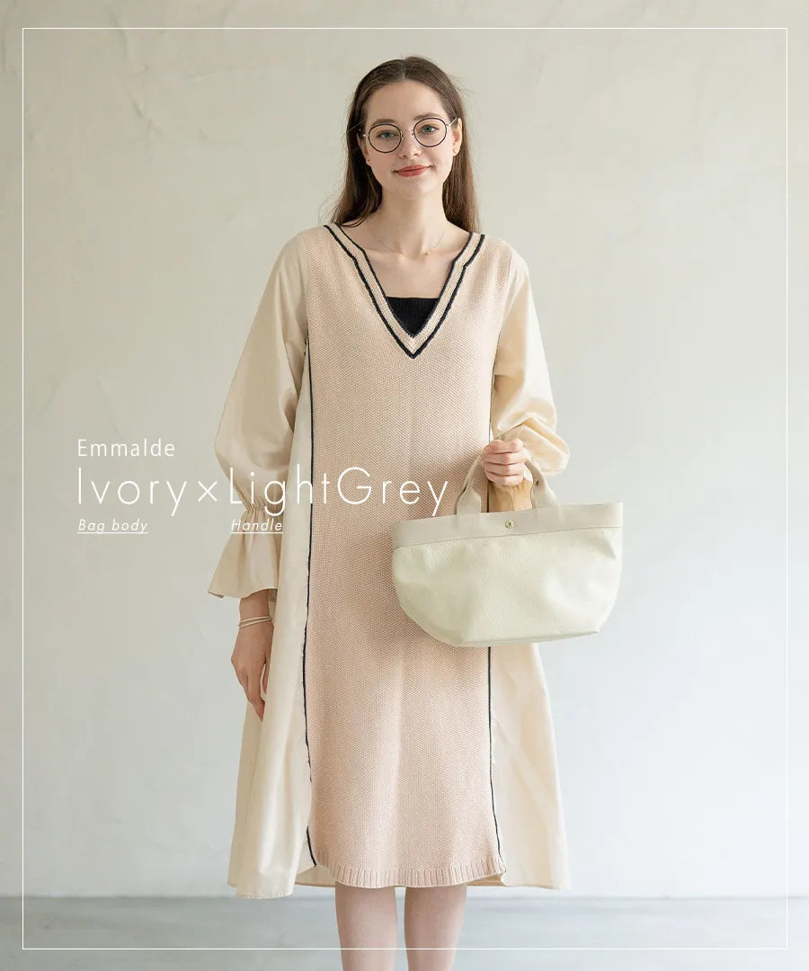 A female model is holding a tote bag "Emmalde" in colors: ivory x light gray.