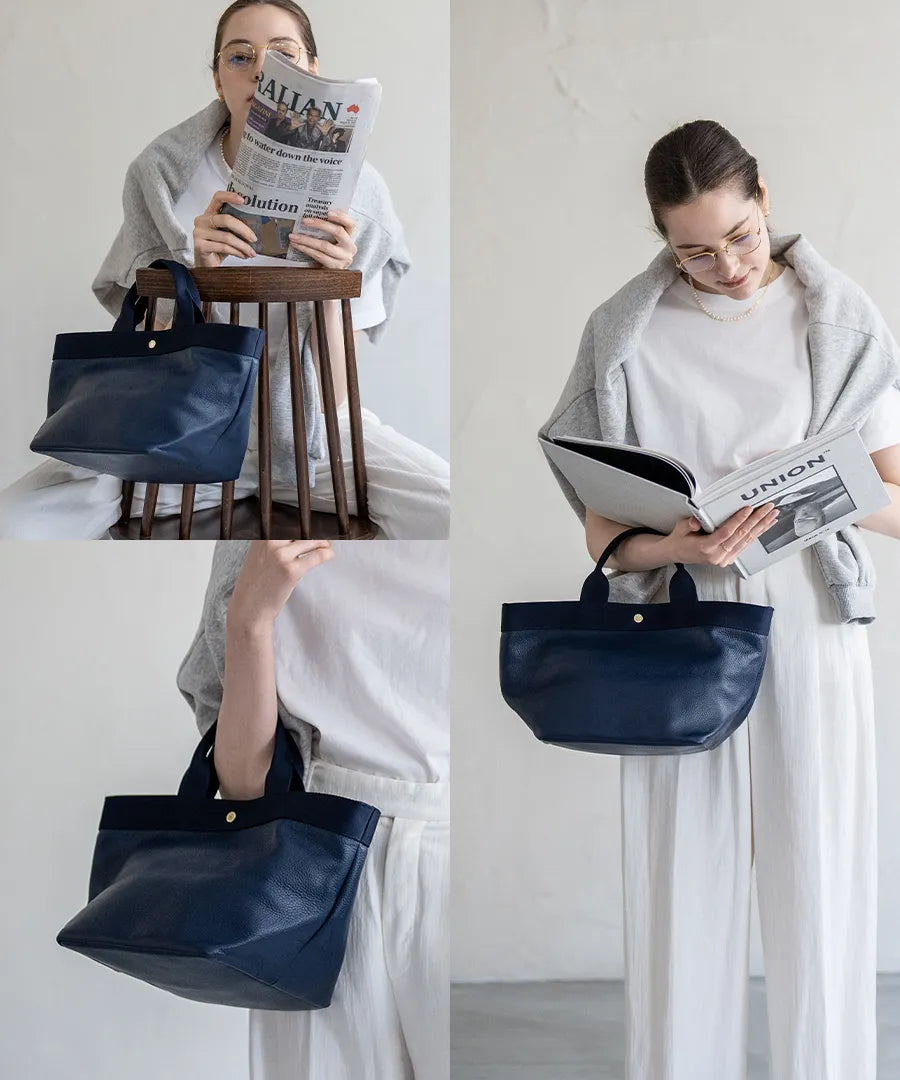 A female model is holding a tote bag "Emmalde" in colors: Navy x Navy.