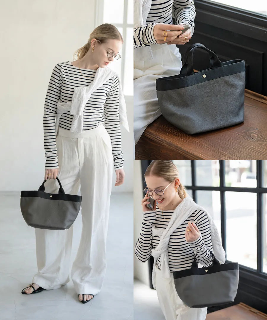 A female model is holding a tote bag "Emmalde" in colors: Dark gray×Black.