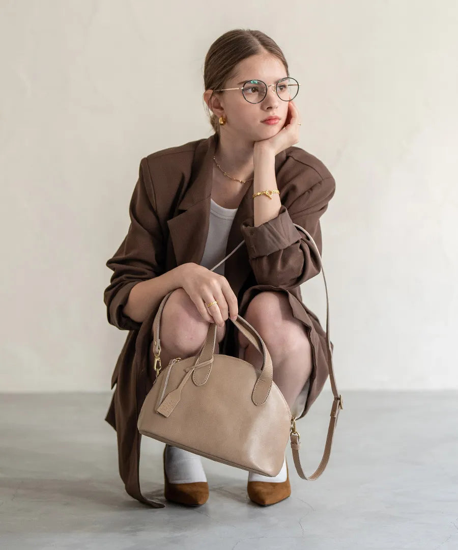 A female model is holding a tote bag "Ervi". Color: Sand greige