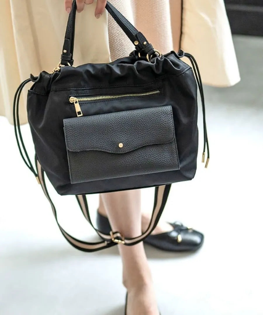 A female model is holding a shoulder bag "Fordone S".Color:Black