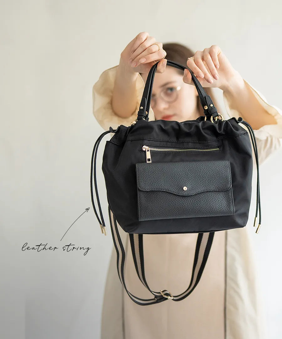 A female model is holding a shoulder bag "Fordone S".Color:Black