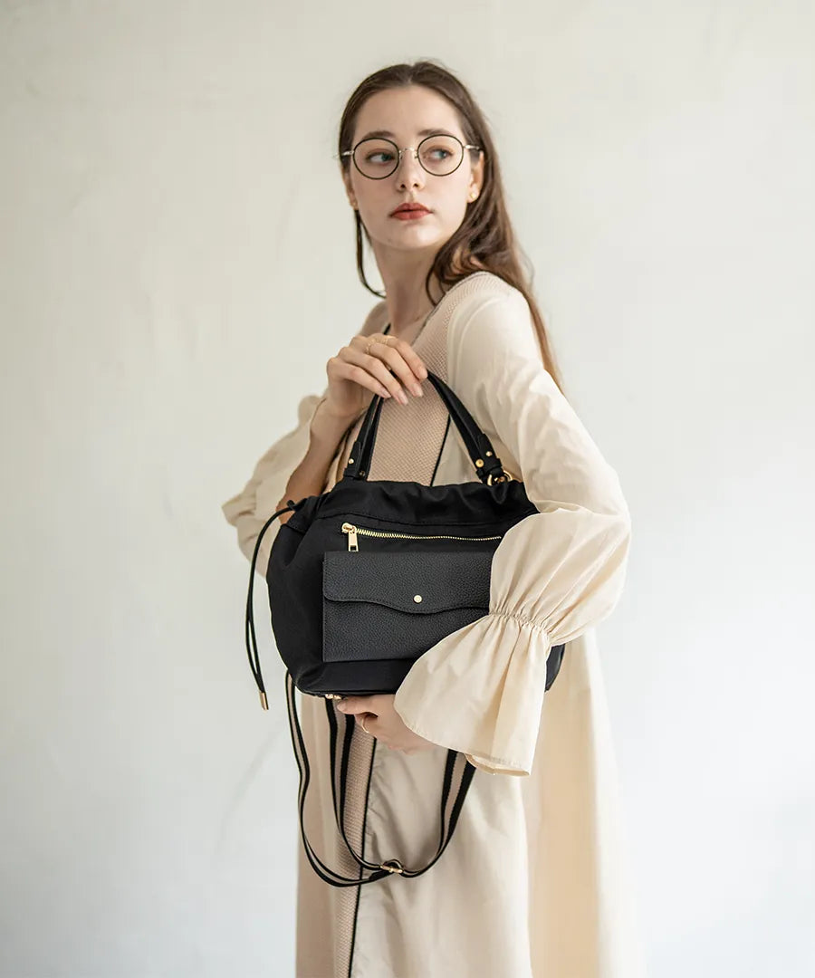 A female model is holding a hand bag "Fordone S".Color:Black