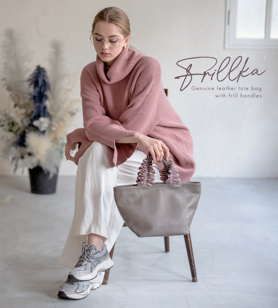 A female model is holding a hand bag "Frillka". Color:Gray x Ash pink