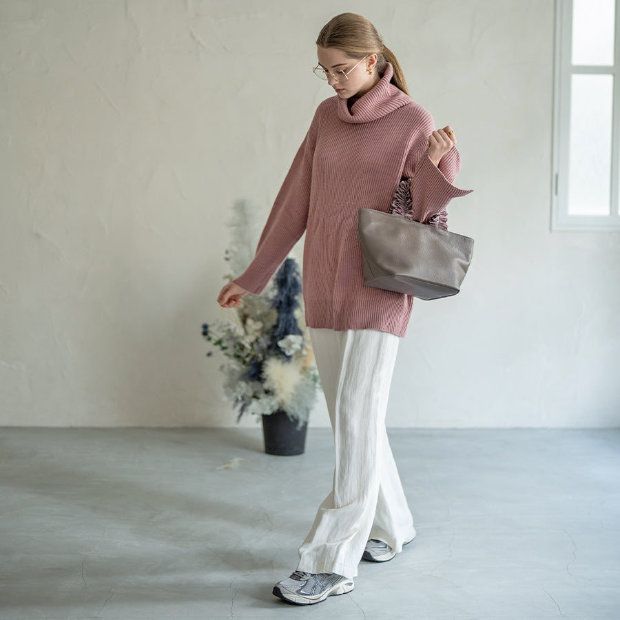 A female model is holding a hand bag "Frillka". Color:Light greige x Gray