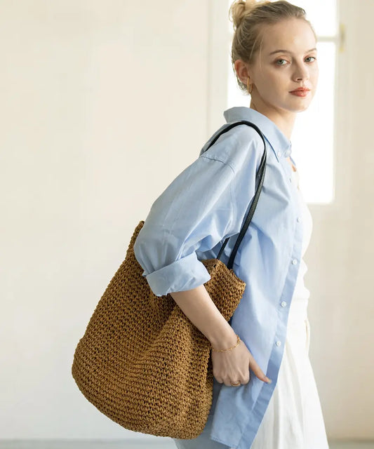 A female model is carrying a shoulder bag "Garah" over her shoulder.Color:
Natural