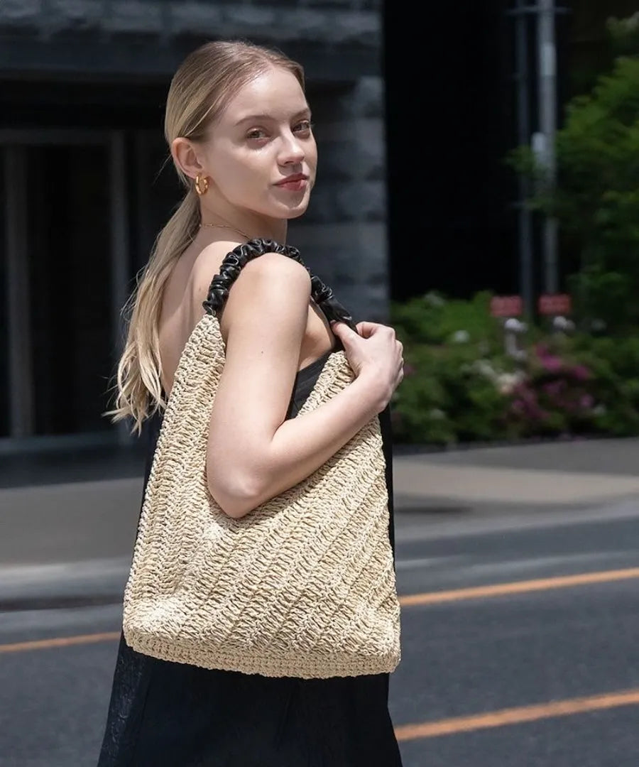 A female model is carrying a tote bag "Garnea" over her shoulder.Color:Natural beige