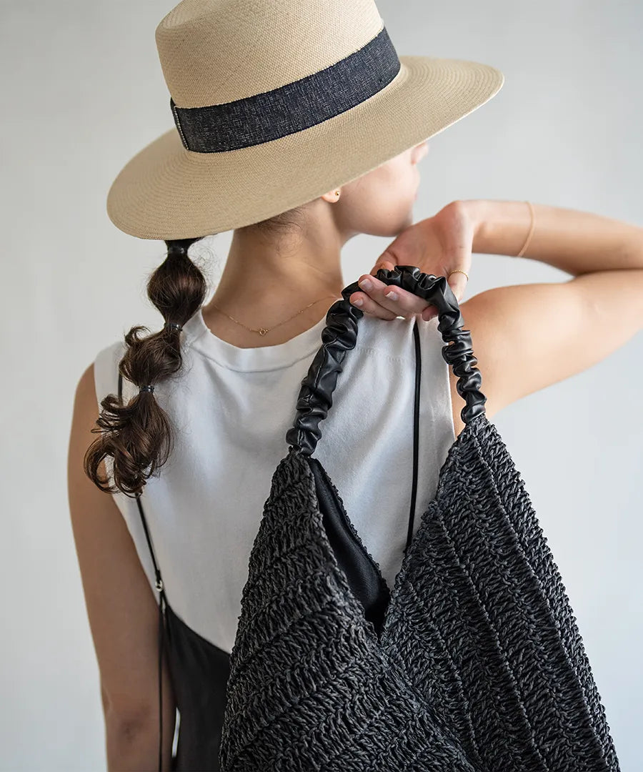 A female model is holding a tote bag "Garnea".Color:Black