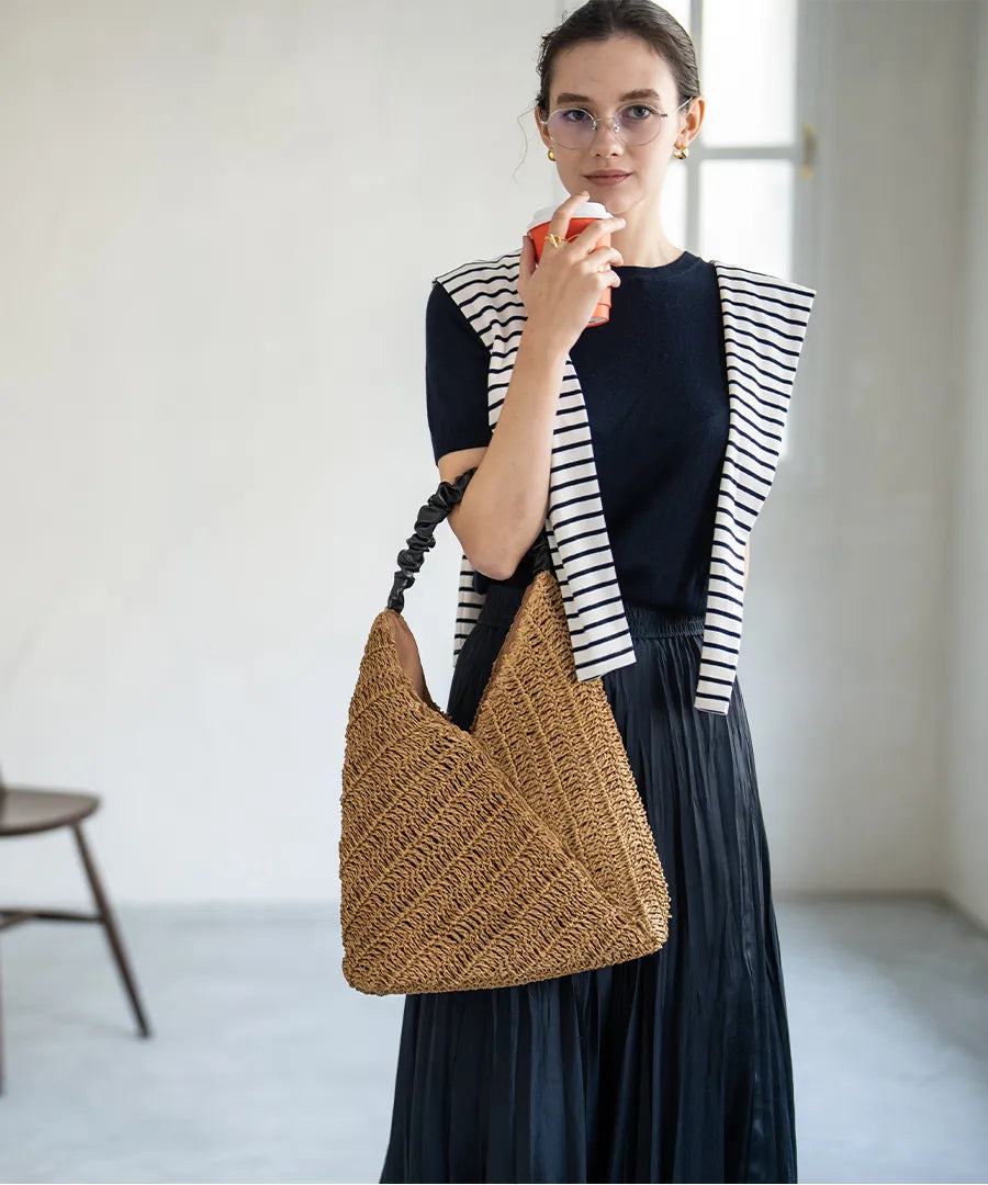 A female model is holding a tote bag "Garnea".Color:Natural camel