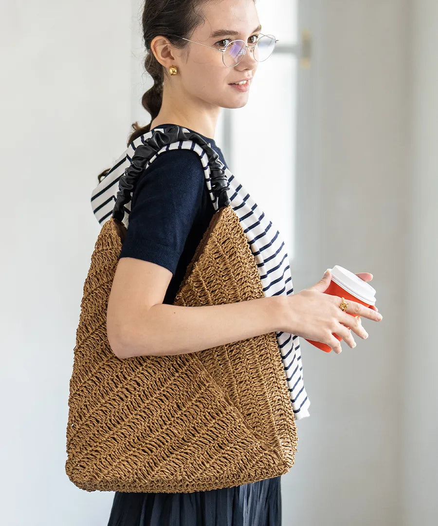 A female model is carrying a tote bag "Garnea" over her shoulder.Color:Natural camel