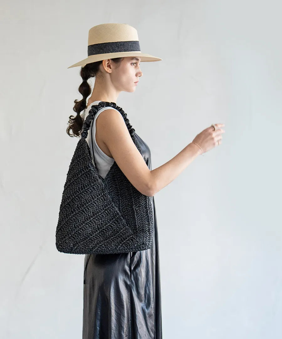 A female model is carrying a tote bag "Garnea" over her shoulder.Color:Black