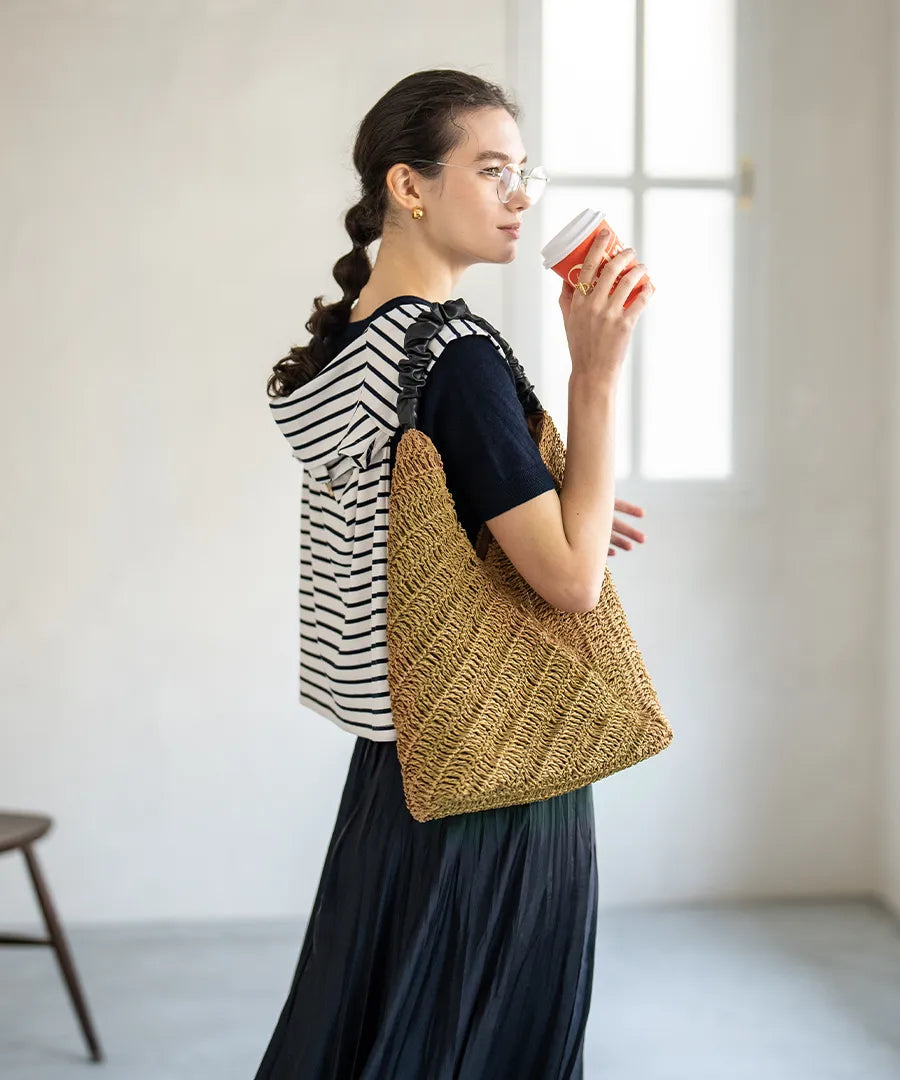 A female model is carrying a tote bag "Garnea" over her shoulder.Color:Natural camel