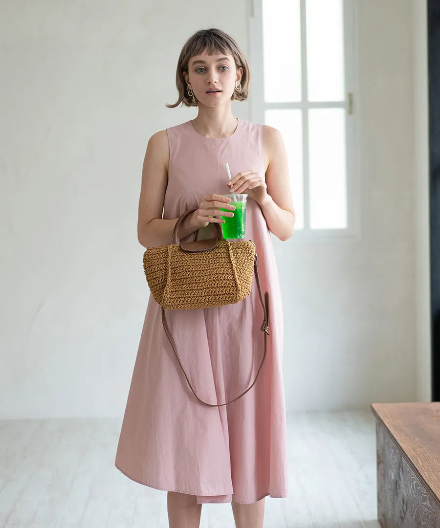 A female model is holding a hand bag "Glenda".Color:Natural × Mocha brown