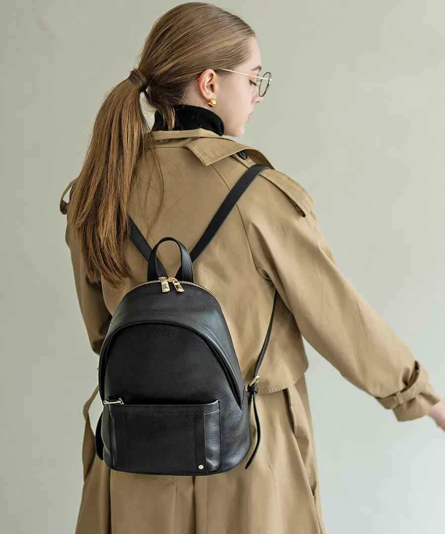 A female model is carrying a backpack "Arioso". Color:Black