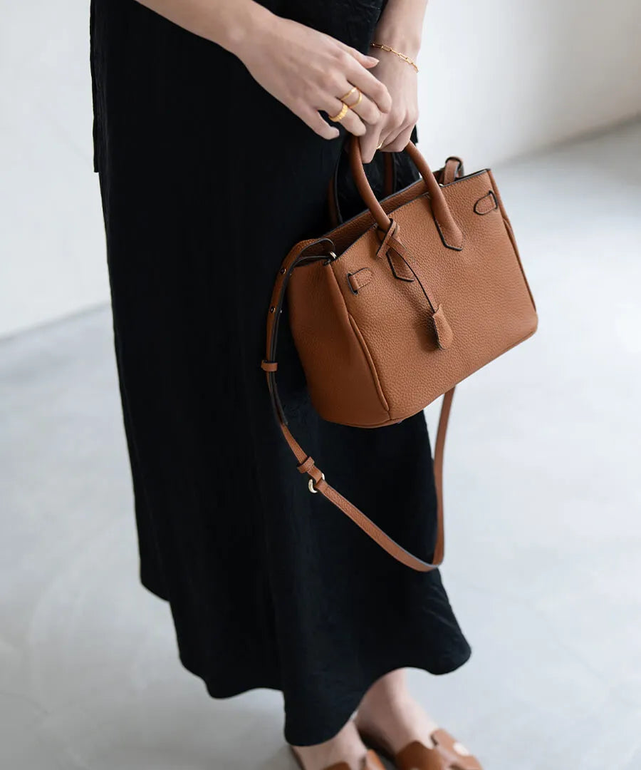 A female model is holding a tote bag "Lenne". Color:Camel