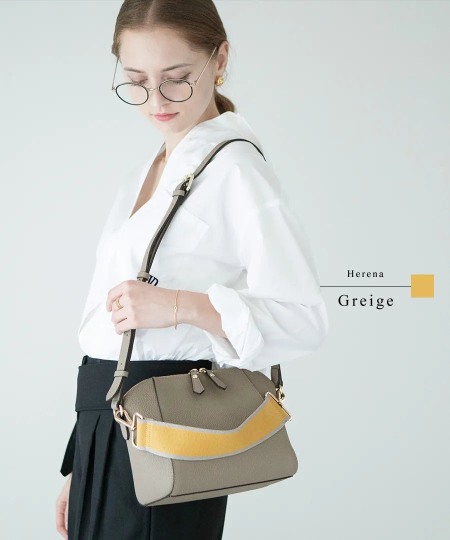 A female model is carrying a shoulder bag "Herena" over her shoulder. Color:Greige