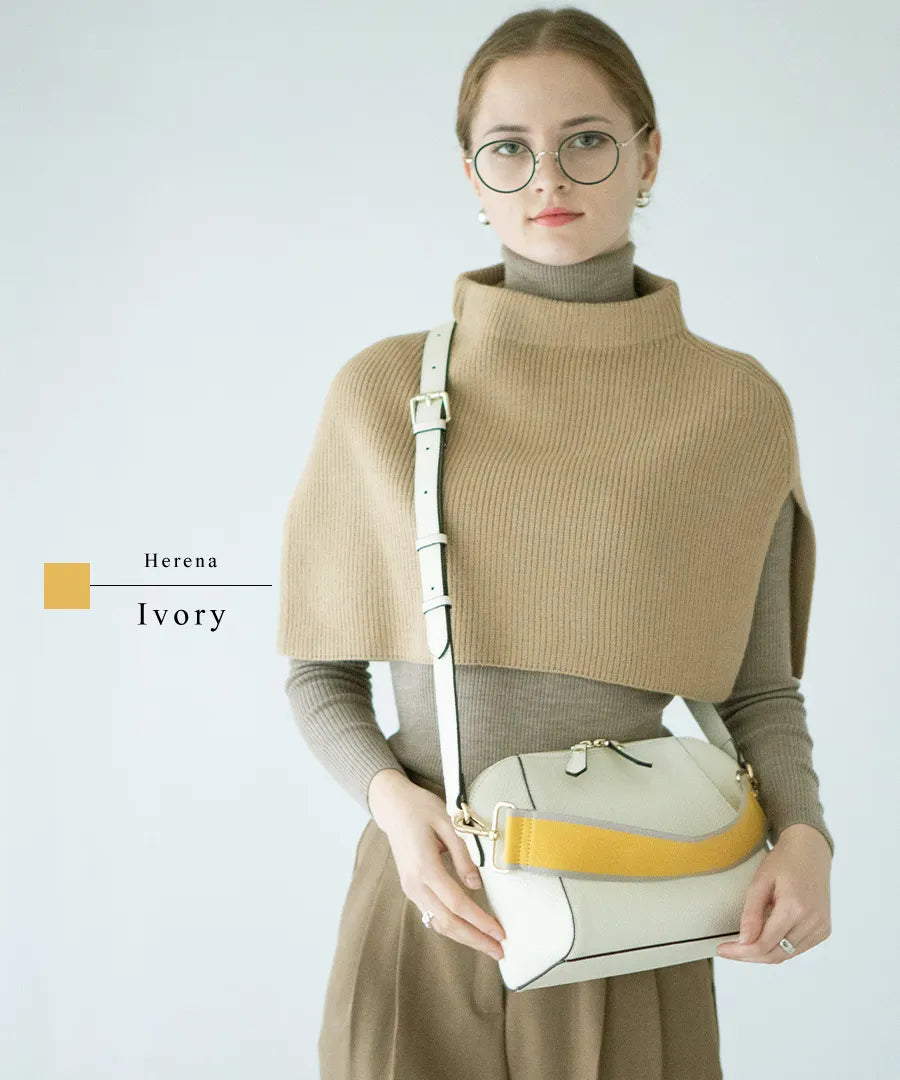 A female model is carrying a shoulder bag "Herena" over her shoulder. Color:Ivory