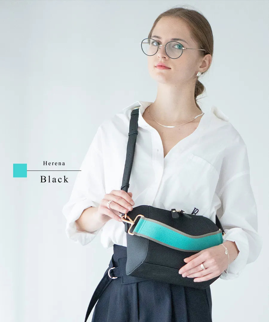 A female model is carrying a shoulder bag "Herena" over her shoulder. Color:Black