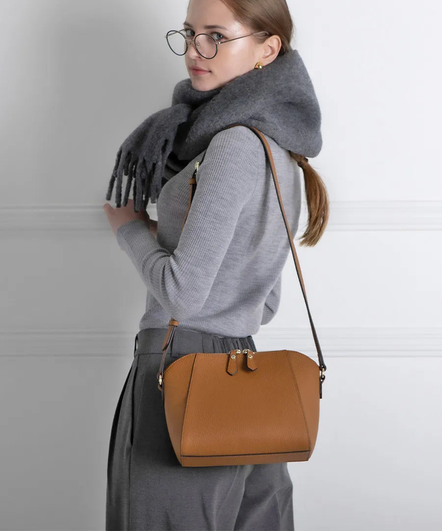 A female model is carrying a shoulder bag "Herena" over her shoulder. Color: Camel