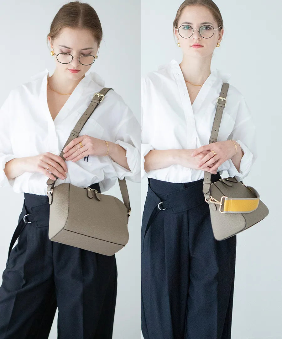 A female model is carrying a shoulder bag "Herena" over her shoulder. Color:Greige