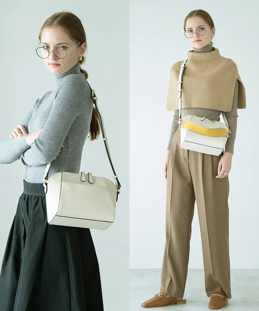 A female model is carrying a shoulder bag "Herena" over her shoulder. Color:Ivory